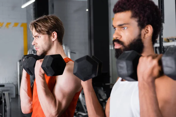 Joven Deportista Haciendo Ejercicio Con Mancuernas Cerca Borrosa Afro Americano — Foto de Stock