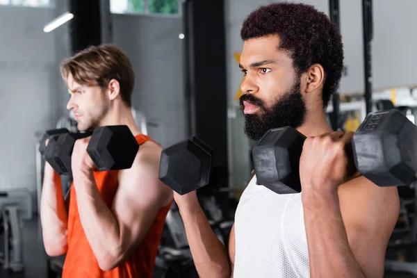Bearded African American Man Training Dumbbells Blurred Friend — Stock Photo, Image