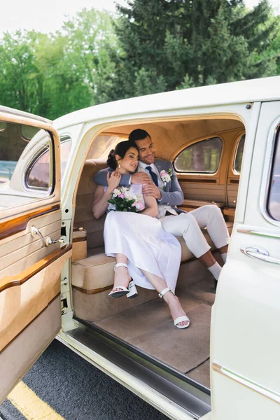 Lächelnde Frischvermählte Umarmen Sich Mit Geschlossenen Augen Retro Auto — Stockfoto