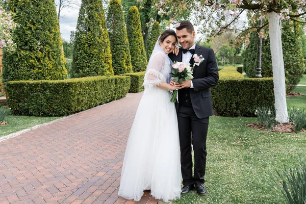 Cheerful Bride Bouquet Hugging Groom Park — Stock Photo, Image