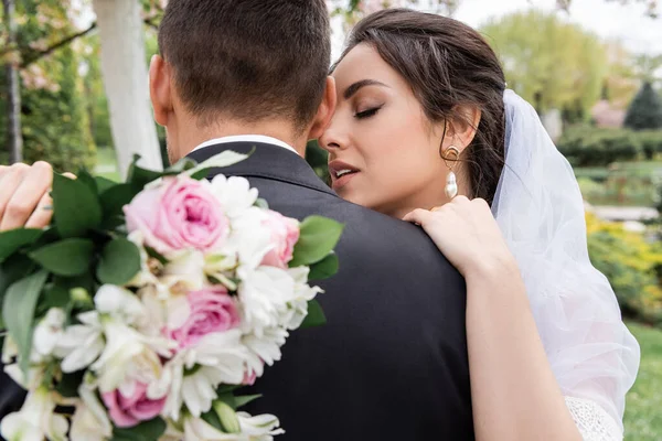 Hübsche Braut Mit Verschwommenem Strauß Umarmt Bräutigam Park — Stockfoto