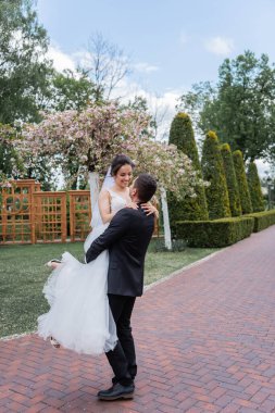 Damat parkta el ele tutuşup gülümsüyor. 