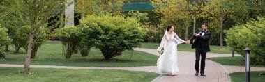 Gülümseyen damat parktaki gelini işaret ediyor. 