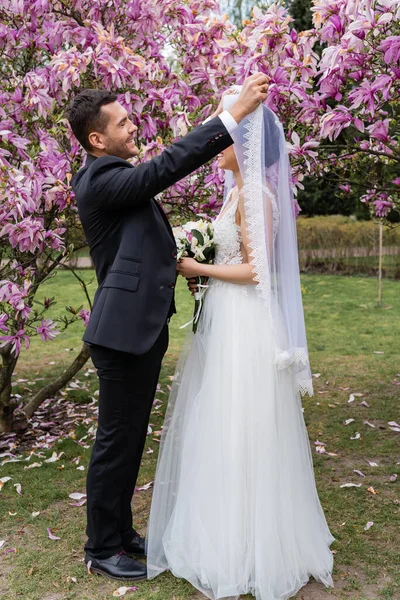 Vista Laterale Dello Sposo Sorridente Che Toglie Velo Dalla Sposa — Foto Stock