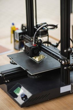 high angle view of 3D printer creating plastic model on blurred background