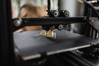 close up view of 3D printer creating plastic figure in modern office