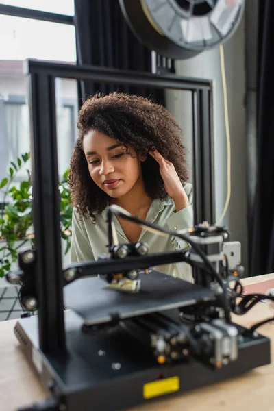 Sorridente Giovane Donna Afroamericana Guardando Stampante Regolando Capelli Ufficio Moderno — Foto Stock