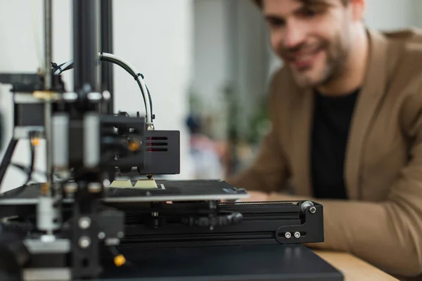 Impressora Produzindo Modelo Plástico Perto Homem Sorrindo Jovem Borrado Escritório — Fotografia de Stock