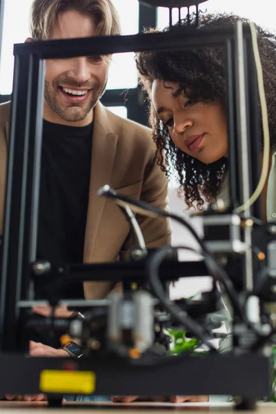 Positivi Giovani Colleghi Interrazziali Guardando Stampante Che Produce Figura Plastica — Foto Stock