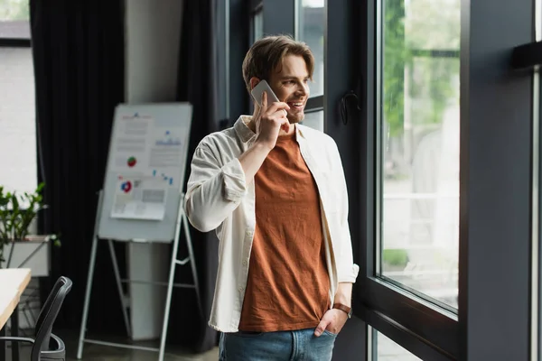 Glimlachende Jonge Man Praten Mobiele Telefoon Buurt Flip Met Grafieken — Stockfoto