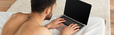Yatağında boş ekran olan dizüstü bilgisayar kullanan serbest çalışan birinin arka planı, afiş. 