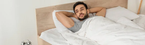 Молодий Чоловік Дивиться Ліжко Вранці Банер — стокове фото