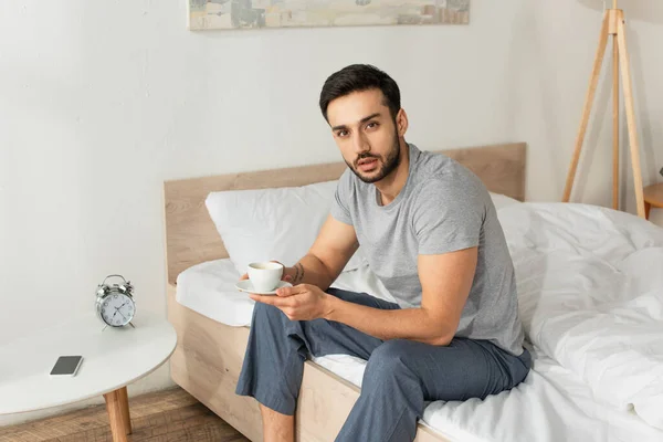 Hombre Pijama Sosteniendo Una Taza Café Mientras Está Sentado Cama — Foto de Stock