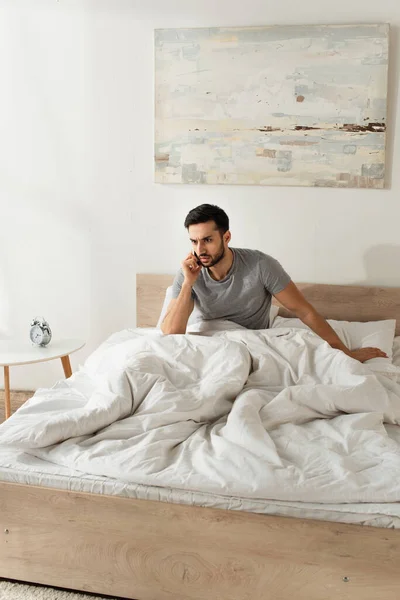 Konzentrierter Mann Telefoniert Morgens Auf Dem Bett Mit Smartphone — Stockfoto