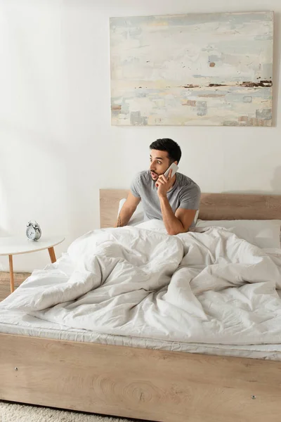 Amazed Man Talking Mobile Phone Bedroom — Stock Photo, Image