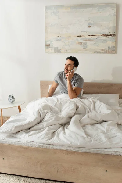 Hombre Feliz Hablando Teléfono Móvil Cama Cerca Del Reloj Despertador — Foto de Stock