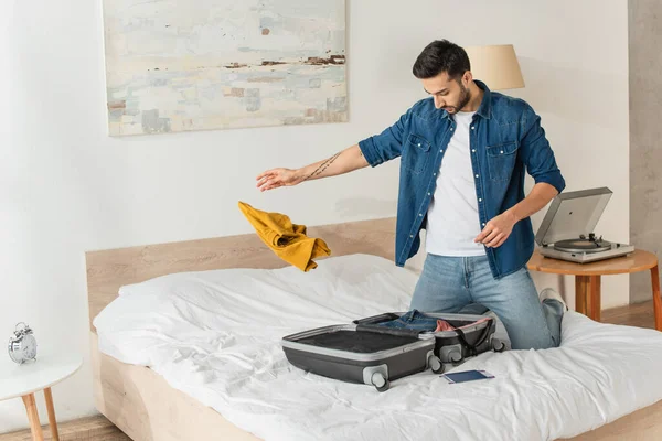 Homem Jogando Roupas Perto Mala Passaporte Cama — Fotografia de Stock