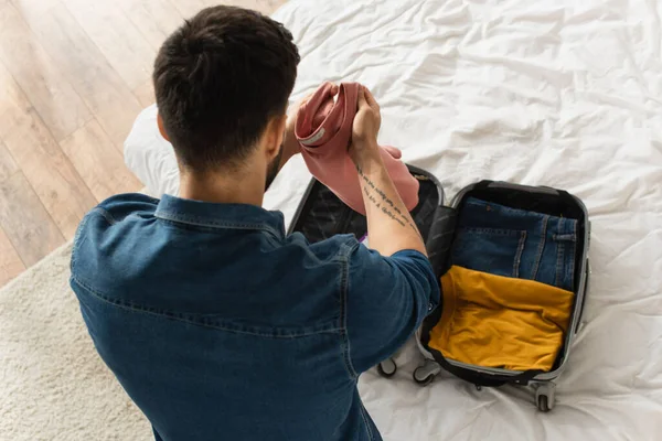 Overhead View Man Holding Clothes Blurred Suitcase Bed — Stock Photo, Image