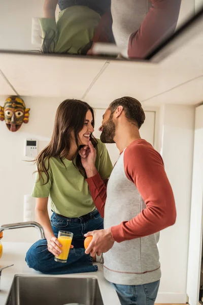 Cheerful Man Touching Chin Girlfriend Glass Orange Juice Kitchen — Stock Photo, Image