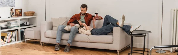 Young Couple Holding Glasses Wine Couch Home Banner — Stock Photo, Image