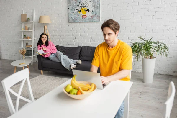 Young Woman Casual Clothes Lying Book Couch Blurred Boyfriend Sitting — Stock Photo, Image