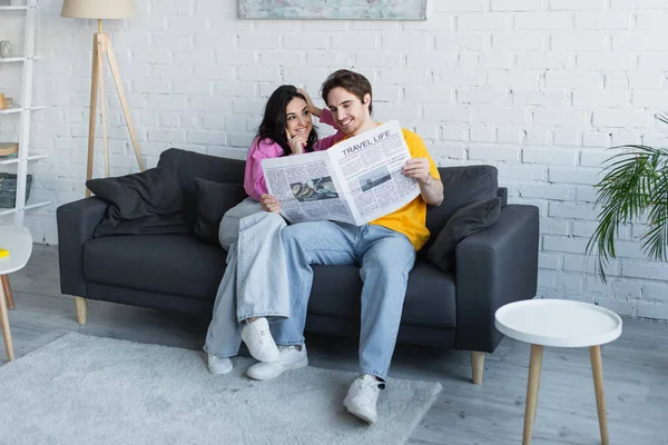 Smiling Young Couple Sitting Couch Holding Newspaper Home — Stock Photo, Image