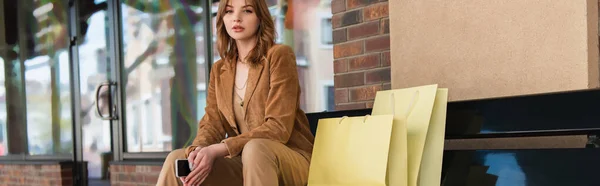 Mujer Joven Con Teléfono Inteligente Sentado Cerca Bolsas Compras Banco — Foto de Stock