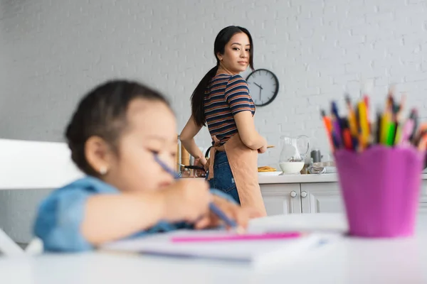 Aziatische Vrouw Zoek Naar Dochter Tekening Terwijl Koken Keuken — Stockfoto