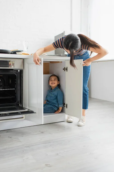 Madre Guardando Allegro Asiatico Bambino Cucina Cabinet — Foto Stock