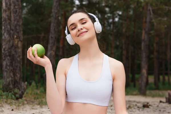 Kulaklıklı Mutlu Kadın Dışarıda Elma Tutarken Müzik Dinliyor — Stok fotoğraf