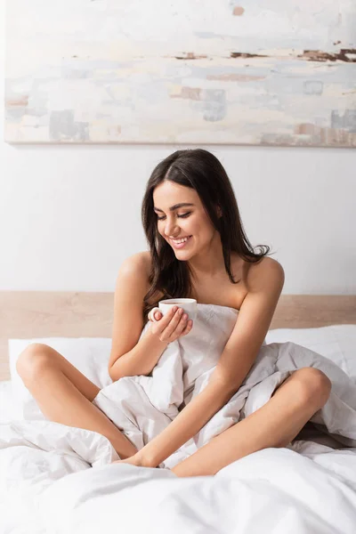 Jovem Morena Mulher Sorrindo Enquanto Segurando Xícara Café Cama — Fotografia de Stock