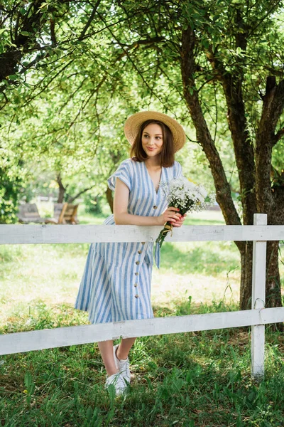 Donna Sorridente Cappello Sole Che Tiene Bouquet Vicino Alla Recinzione — Foto Stock