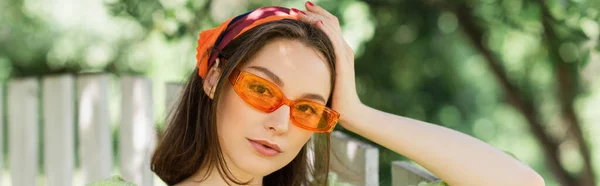 Mujer Joven Gafas Sol Mirando Cámara Cerca Valla Aire Libre — Foto de Stock