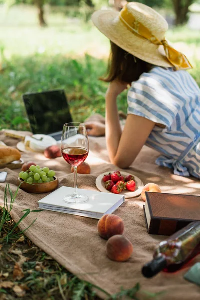 Wine Books Fruits Blanket Blurred Woman Using Laptop Park — Stock Photo, Image