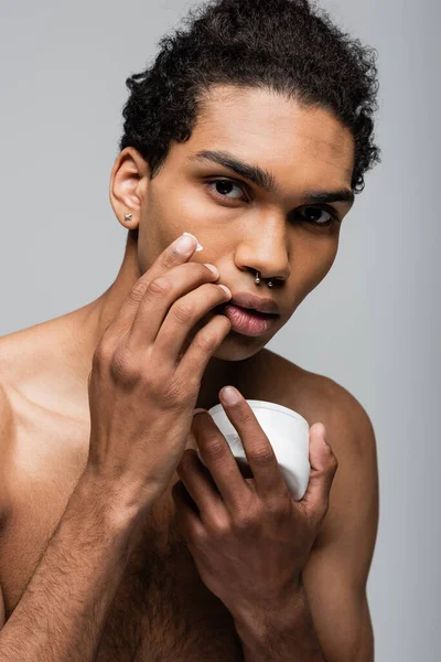 Joven Afroamericano Hombre Aplicando Crema Facial Aislado Gris —  Fotos de Stock