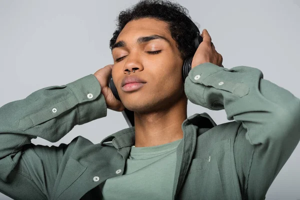 Young African American Man Touching Headphones While Listening Music Closed — Stock Photo, Image