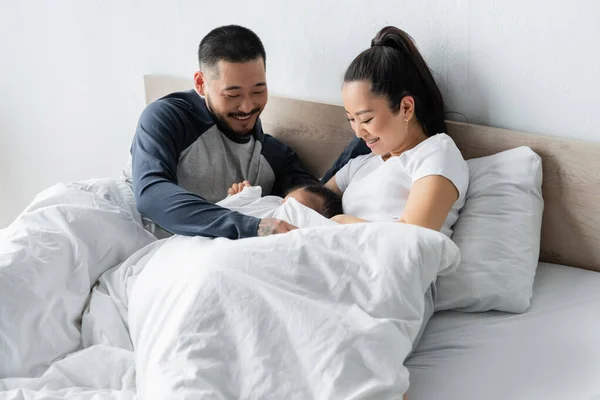 Alegre Asiático Padres Mirando Hija Cama —  Fotos de Stock