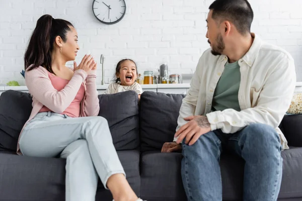 Glückliches Asiatisches Kind Versteckt Sich Neben Verschwommenen Eltern Auf Dem — Stockfoto