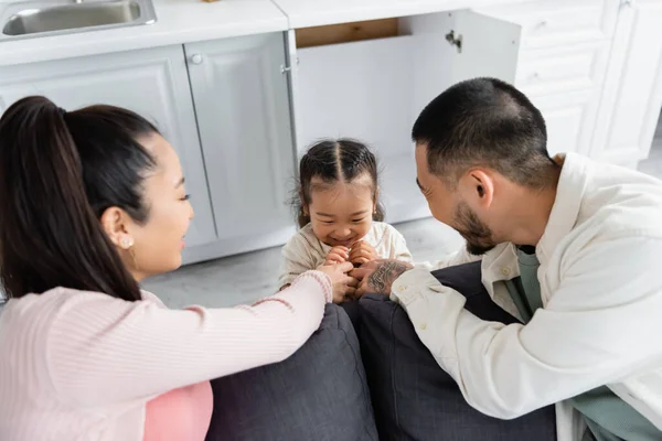 Glückliches Asiatisches Kind Versteckt Sich Küchenschrank Neben Verschwommenen Eltern Auf — Stockfoto