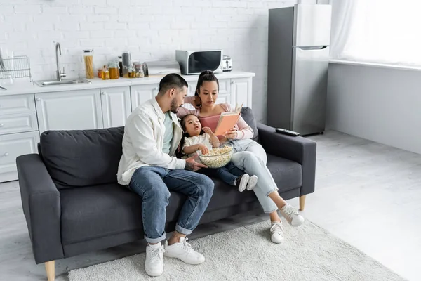 Asiatisk Unge Äter Popcorn Nära Föräldrar Vardagsrummet — Stockfoto