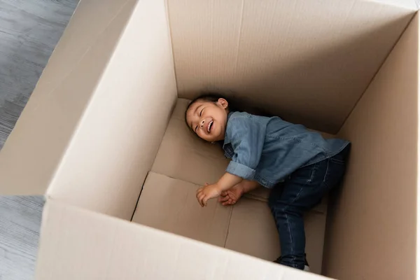 Hochwinkelaufnahme Eines Glücklichen Asiatischen Kleinkindes Das Einem Leeren Karton Liegt — Stockfoto