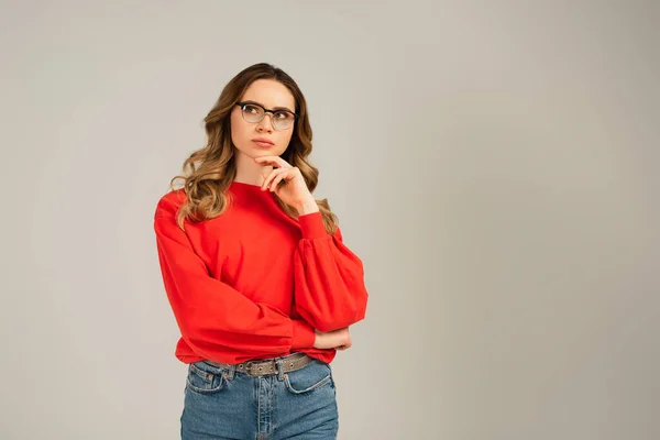 Nachdenkliche Und Lockige Frau Mit Brille Die Isoliert Auf Grau — Stockfoto