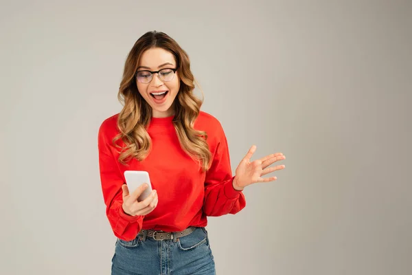 Excited Woman Eyeglasses Holding Smartphone Isolated Grey — Stock Photo, Image