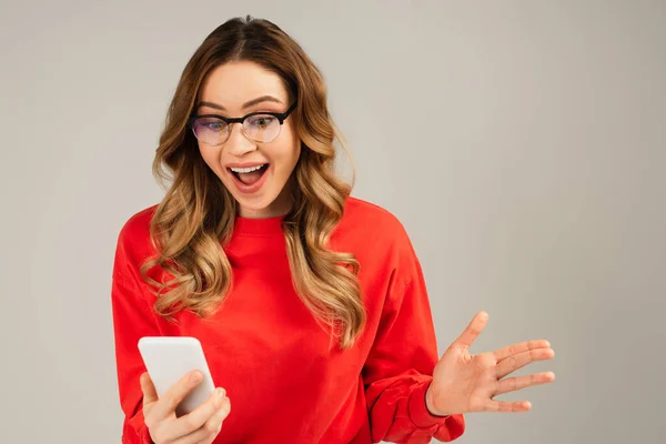 Mujer Excitada Gafas Mirando Teléfono Móvil Aislado Gris —  Fotos de Stock