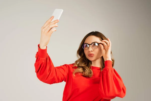 Vrouw Aanpassen Bril Tijdens Het Nemen Van Selfie Smartphone Geïsoleerd — Stockfoto