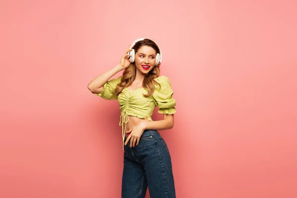 Flirty Woman Adjusting Wireless Headphones Pink — Stock Photo, Image