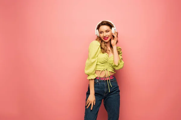Cheerful Woman Adjusting Wireless Headphones Pink — Stock Photo, Image