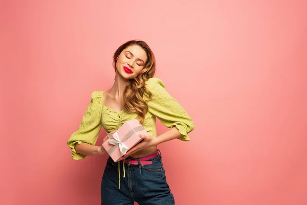 Mujer Complacida Con Los Ojos Cerrados Sosteniendo Regalo Envuelto Aislado — Foto de Stock