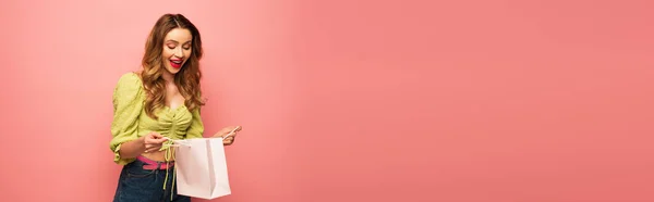 Mulher Espantada Blusa Verde Olhando Para Saco Compras Isolado Rosa — Fotografia de Stock