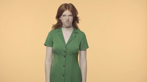 怒っ十代の女の子で緑のドレス眉をひそめて黄色に隔離された — ストック動画